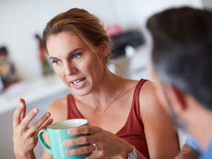 Cropped shot of an attractive young woman having a serious conversation with her husband while holding a cup of coffee
