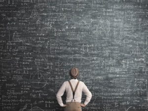 man think how to solve the problem staring a giant chalkboard with mathematical formula